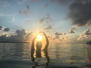 a person standing in front of a sunset